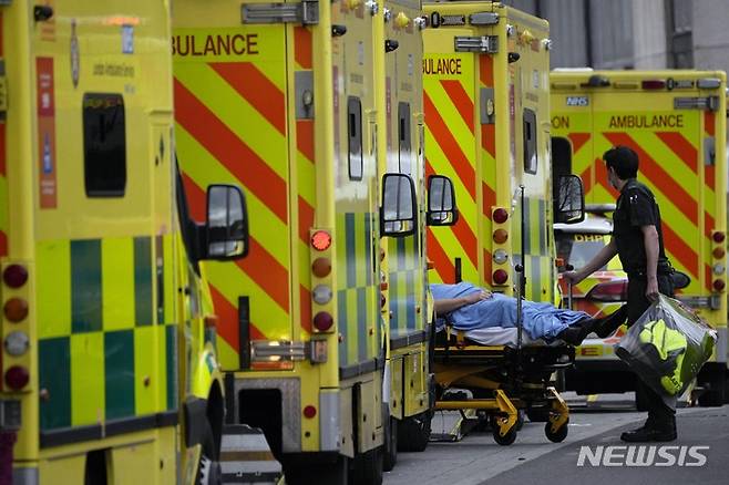 [런던=AP/뉴시스]영국 런던 동부 로열 런던 병원에 구급차로 도착한 코로나19 환자가 들것에 실려 이송되고 있다. 2022.01.07.
