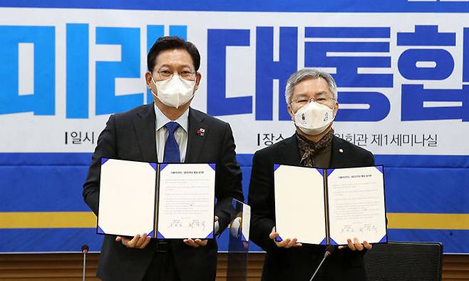 길 더불어민주당 대표(왼쪽)와 최강욱 열린민주당 대표가 지난 2021년 12월 26일 서울 여의도 국회에서 더불어민주당·열린민주당 통합과 관련해 만나 합의문에 서명하고 있다. 뉴시스