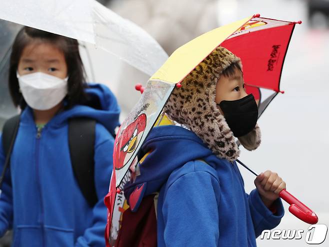비가 내리며 쌀쌀한 날씨를 보인 9일 서울 종로구 광화문 일대에서 한 아이가 털모자를 쓰고 있다. 2021.11.9/뉴스1 © News1 이성철 기자
