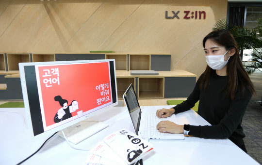 LX하우시스 임직원이 'LX 지인 인테리어 고객 언어 가이드북'을 살펴보고 있는 모습. <LX하우시스 제공>