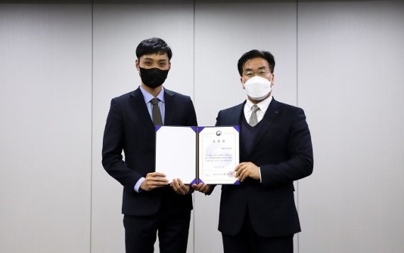 위니아딤채 대외협력담당 조경형 상무(오른쪽)가 법무부 보호정책과 김동하 사무관에게 법무부 장관 표창장을 전달받고 있다. 위니아딤채 제공