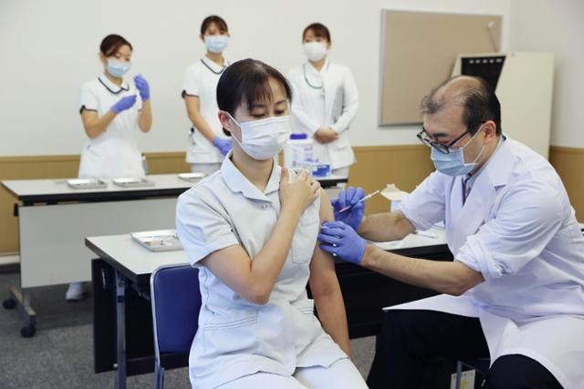 일본 수도 도쿄에서 지난 1일 도쿄 메디컬 센터 근무자가 화이자의 신종 코로나바이러스 감염증(코로나19) 백신 3차 접종(부스터샷)을 하고 있다. 일본은 이날 200만 명에 달하는 의료종사자들을 대상으로 3차 접종을 개시했으나 7일까지 3차 접종률이 0.6%에 머무르고 있다. 도쿄=교도 연합뉴스