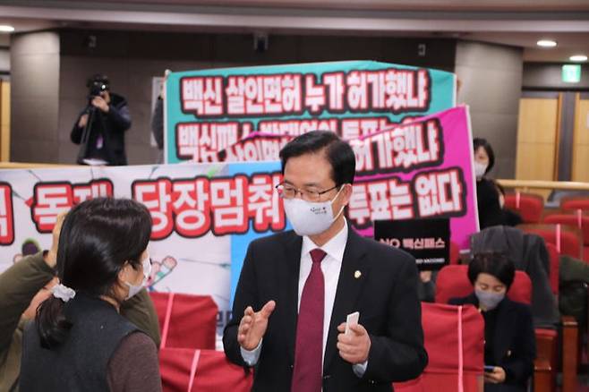 국민의힘 최춘식 의원이 지난 4일 서울 여의도 국회의원회관에서 주최한 ‘청소년 코로나 백신 부작용 피해 학부모 간담회’에서 한 참석자와 대화를 나누고 있다. 최춘식의원실 제공