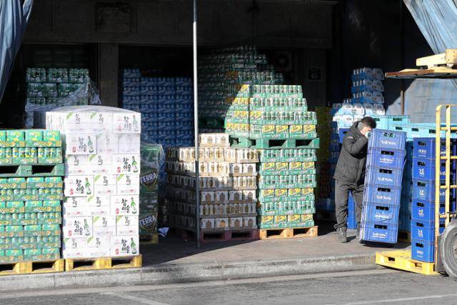 지난 11일 오전 서울 동대문구 청량리종합도매시장에서 한 상인이 주류 상자를 옮기고 있다. 뉴시스