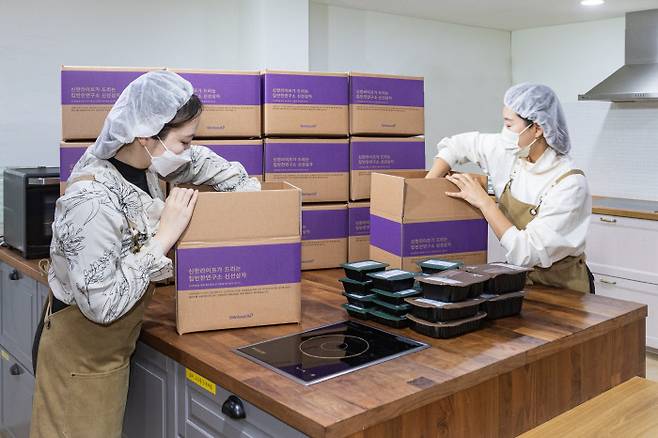 신한라이프빛나는재단 관계자들이 결식 우려 아동들에게 보낼 건강 도시락을 상자에 담고 있다. 신한라이프 제공
