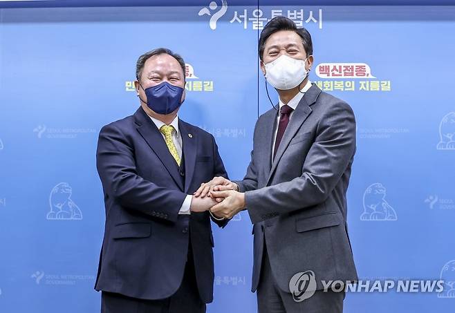 두 손 잡은 오세훈 시장-김인호 의장 (서울=연합뉴스) 윤동진 기자 = 오세훈 서울시장과 김인호 서울시의회 의장이 12일 서울시청에서 열린 서울시 민생지킴 종합대책 발표를 마친 후 기념촬영을 하고 있다. 2022.1.12 mon@yna.co.kr