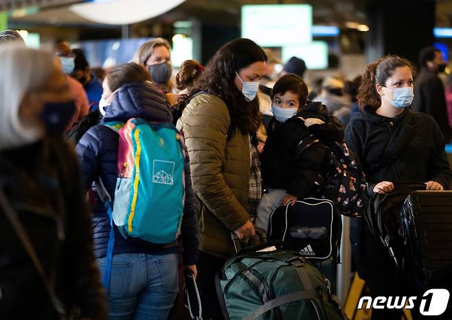 한 가족이 27일(현지시간) 미국 워싱턴주 시애틀의 시애틀 타코마 국제공항에서 수십편의 항공편이 결항 또는 지연되자 줄을 서서 기다리고 있다. 2021.12.29/news1 © 로이터=뉴스1 © News1 김민수 기자