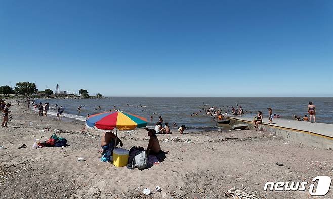 사람들이 2022년 1월 12일(현지시간) 아르헨티나 부에노스아이레스에서 폭염을 피하기 위해 강가로 피신했다. © 로이터=뉴스1 © News1 김지현 기자