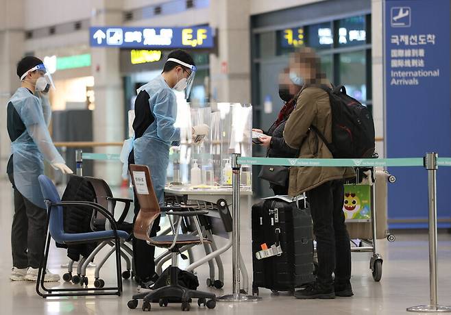 지난 2021년 1월 3일 인천공항 입국장에서 한 외국인이 관계자에게 안내를 받고 있다. 연합뉴스