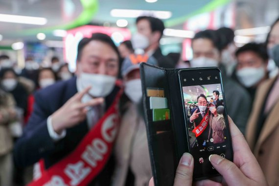 [부산=뉴시스] 김선웅 기자 = 윤석열 국민의힘 대선 후보가 14일 부산 서면을 찾아 시민들과 인사를 나누고 기념촬영을 하고 있다. (사진=윤석열 후보 캠프 제공) 2022.01.14. photo@newsis.com <저작권자ⓒ 공감언론 뉴시스통신사. 무단전재-재배포 금지.> /사진=뉴시스화상