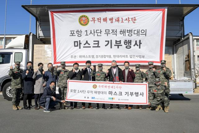 정영태(왼쪽 일곱 번째) 위머스트앰 대표와 영화배우 이동준(오른쪽에서 다섯 번째)씨 등이 해병 1사단에 마스크를 전달하고 있다. 위머스트엠 제공