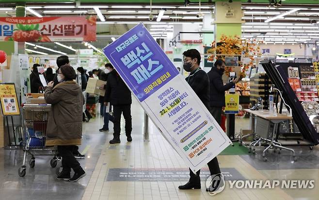 방역패스 안내문 치우는 마트 관계자 (서울=연합뉴스) 한종찬 기자 = 법원이 서울 마트·백화점에 대해 방역패스 효력 정지를 결정한 14일 오후 서울 서초구 양재동 농협하나로마트에서 관계자가 방역패스 안내문을 치우고 있다. 2022.1.14 saba@yna.co.kr