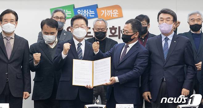 이재명 더불어민주당 대선 후보가 강원도 매타버스(매주 타는 민생버스) 민생투어 첫 날인 15일 강원 춘천시 강원도의회에서 열린 강원도 18개 시군 번영회장 간담회에서 정책 건의문을 전달받으며 기념촬영을 하고 있다. 2022.1.15/뉴스1 © News1 오대일 기자