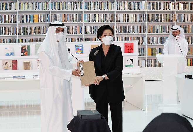 김정숙 여사가 16일(현지 시각) 아랍에미리트(UAE) 두바이 모하메드빈라시드(MBR) 도서관에서 열린 한-UAE 지식문화 교류식에서 모하메드 살람 알마즈루이 MBR 도서관장에게 훈민정음 해례본 영인본을 기증하고 있다. /연합뉴스