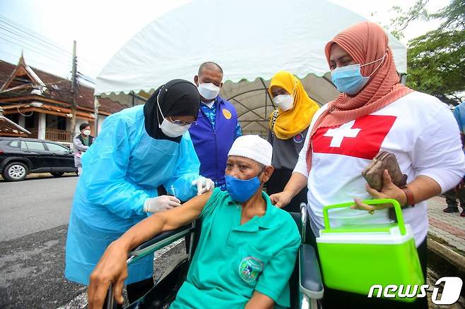 16일(현지시간) 태국 빠따니 거리에서 주민이 코로나19 백신을 접종 받고 있다. © AFP=뉴스1 © News1 우동명 기자