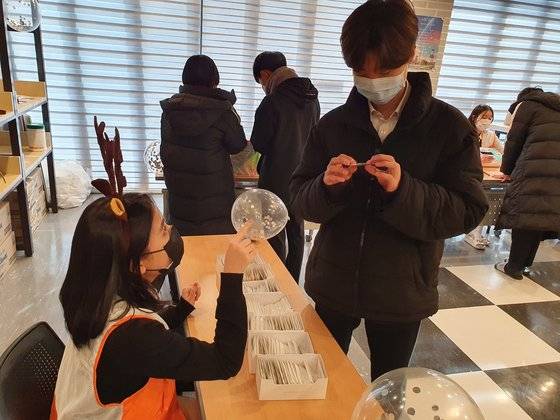 ‘소원 팔찌 캠페인’에 참석한 춘천중 학생이 소원 팔찌를 살펴보고 있다.