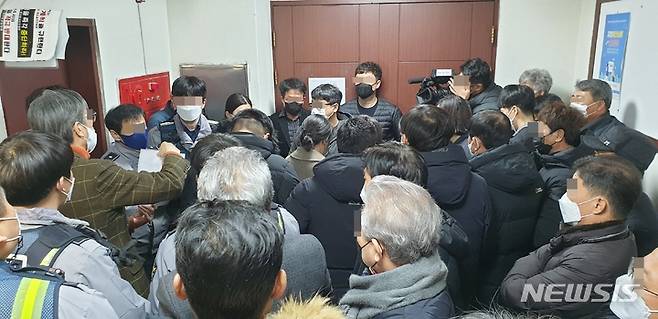 [청주=뉴시스] 임선우 기자 = 충북 청주시 원도심 주민들이 13일 시청 대회의실 앞에서 원도심 경관 고도제한을 심의하려는 도시계획위원회 개최를 막아서고 있다. 주민들은 사유재산권 침해를 이유로 원도심 건축물 높이 제한을 골자로 한 2030 청주시 도시관리계획안을 반대하고 있다. 2022.01.13. imgiza@newsis.com