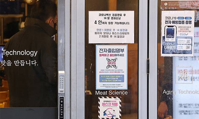 지난 14일 서울 종로구의 한 식당 입구에 방역패스(백신접종증명·음성확인제) 관련 안내문이 부착돼 있다. 연합뉴스