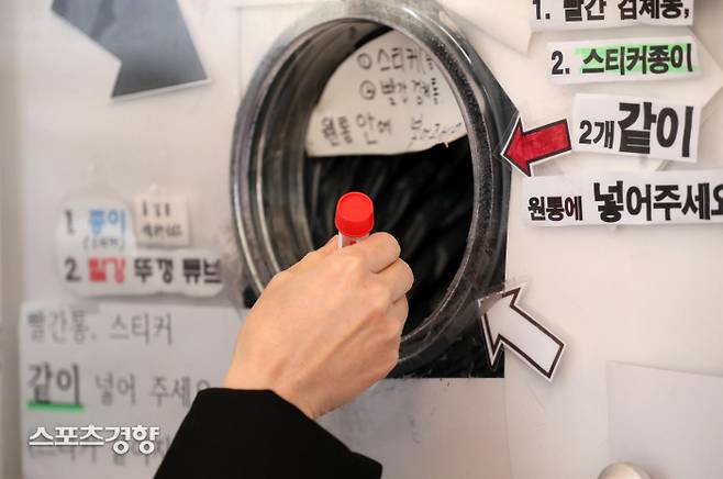 서울시 코로나19 확진자 중 오미크론 변이가 검출되는 비율이 22%를 기록하고 있는 가운데 17일 서울광장 임시선별검사소에서 한 시민이 채취한 검체를 수거함에 넣고 있다. 박민규 선임기자