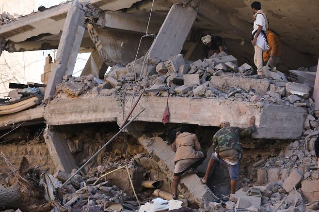 폭격에 무너진 예멘 수도의 건물 사우디아라비아가 주도하는 동맹군이 18일(현지시간) 예멘의 수도 사나에 보복성 공습을 한 현장에서 구조대원들이 무너진 건물 잔해를 파헤치며 생존자를 수색하고 있다.  사나 | 로이터연합뉴스