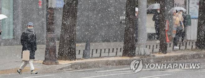 갑자기 내린 눈 [연합뉴스 자료사진] 서울 지역에 눈이 내린 17일 오후 시민들이 횡단보도를 지나고 있다. 2022.1.17
