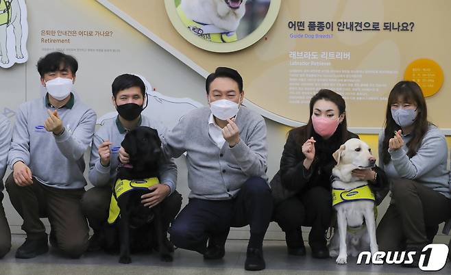 윤석열 국민의힘 대선 후보가 19일 오후 경기도 용인시 처인구 삼성화재 안내견학교를 방문해 장애인 관련 정책공약을 발표한 후 훈련사들과 기념촬영을 하고 있다. 2022.1.19/뉴스1 © News1 국회사진취재단