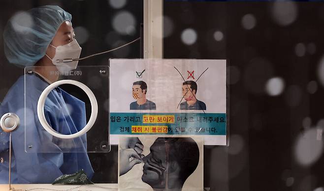 19일 서울 중구 서울역 광장 코로나19 임시 선별검사소에서 눈이 내리는 가운데 의료진이 검체 채취를 준비하고 있다. 연합뉴스