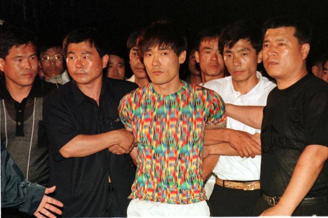 1999년 7월 16일 순천에서 붙잡힌 신창원이 부산교도소로 압송돼 재수감되기 전 취재진에게 모습이 공개되고 있다. 1999년 7월 16일 자 한국일보 자료사진