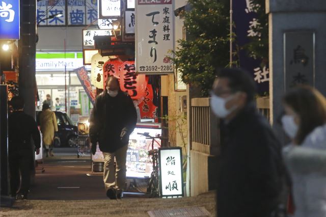 일본 도쿄 시민들이 19일 마스크를 쓴 채 술집과 식당이 있는 거리를 지나가고 있다(왼쪽 사진). 도쿄도는 오미크론 변이로 인한 코로나19 급속 확산으로 음식점 영업시간을 오후 9시까지, 주류 제공 시간은 오후 8시까지로 제한하기로 결정했다. AP연합뉴스