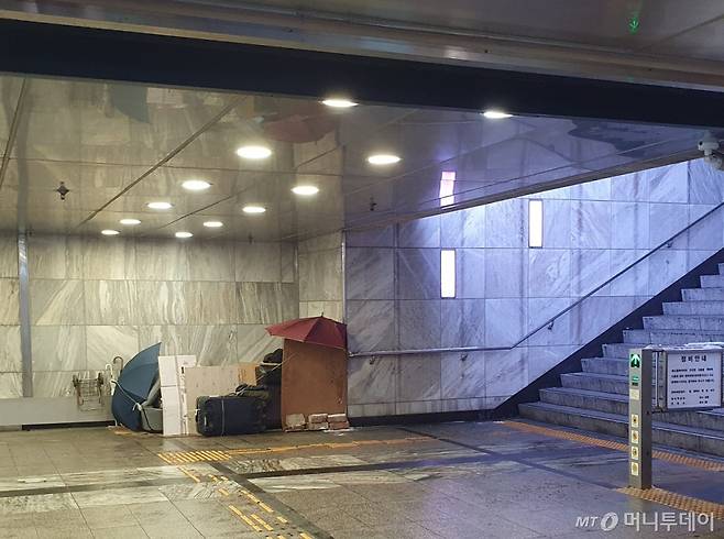 20일 서울 광화문 역사 안에서 한 노숙인이 우산과 박스 등을 활용해 머물 곳을 만들고 있다. /사진= 오진영 기자