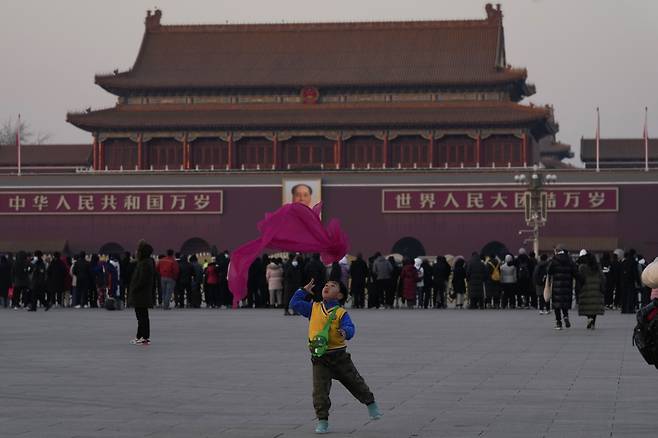 중국 베이징의 톈안먼 광장에서 18일 한 어린이가 스카프로 놀이를 하고 있다. 방역 당국은 베이징 하이뎬구에서 3명의 오미크론 감염자가 확인되자 해당 지역의 일부를 봉쇄했다. [연합]