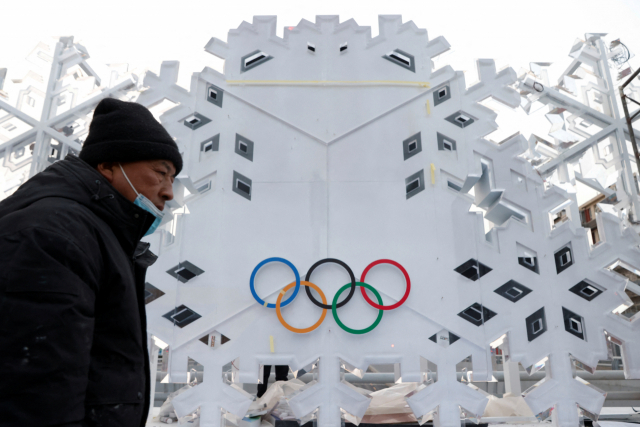 지난 19일 한 남성이 중국 베이징의 올림픽 홍보판 앞을 걸어가고 있다. /로이터연합뉴스