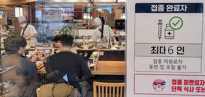 지난 17일 서울 시내의 한 식당에 최대 6인까지 식사가 가능하다는 안내문이 붙어 있다. 연합뉴스.