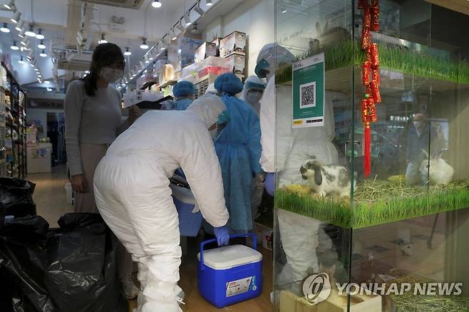 (로이터=연합뉴스) 홍콩 방역 당국 직원들이 지난 19일 애완동물 가게에서 작업하는 모습.