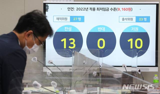 [세종=뉴시스] 강종민 기자 = 박준식 최저임금위원회 위원장(오른쪽)이 지난해 7월12일 밤 제9차 전원회의에서 내년도 최저임금을 9천160원으로 의결한 뒤 위원들과 대화하고 있다.(공동취재사진) 2021.07.13 photo@newsis.com