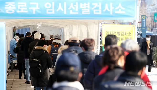 [서울=뉴시스] 홍효식 기자 = 0시 기준 코로나19 신규 확진자가 7,009명으로 집계된 22일 서울 종로구 탑골공원 삼일문 임시선별검사소를 찾은 시민들이 검사를 받기 위해 대기하고 있다. 2022.01.22. yesphoto@newsis.com