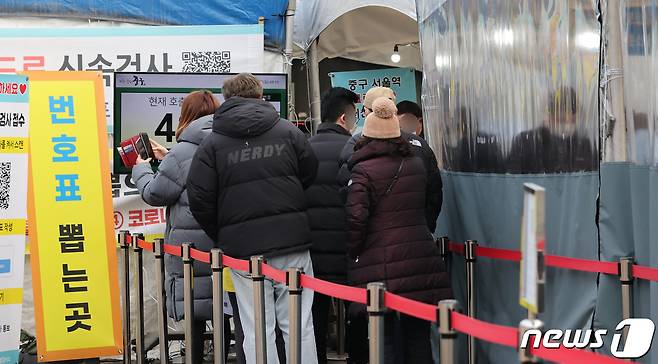 23일 서울 중구 서울역 임시선별검사소를 찾은 시민들이 코로나19 검사를 받기 위해 줄지어 기다리고 있다. 2022.1.23/뉴스1 © News1 박지혜 기자