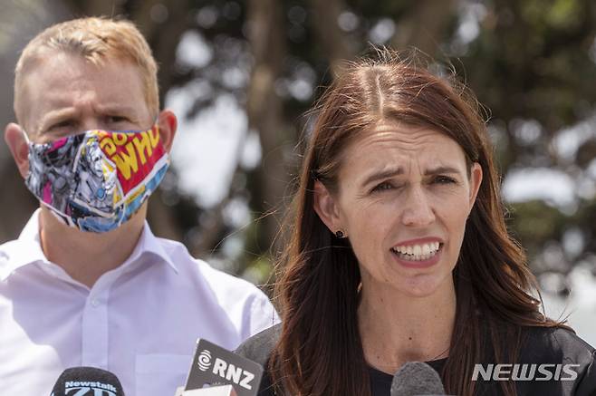 [ 뉴플리머스 ( 뉴질랜드)=AP/뉴시스]저신다 아던 뉴질랜드 총리가 크리스 힙킨스 코로나대응 장관과 함께 코로나19 발생현황과 오미크론 지역 확산에 대해 브리핑을 하고 있다.  오미크론 청정지역이었던 뉴질랜드도 23일밤 11시 59분(현지시간)을 기해 '적색 경보'단계에 돌입했다.