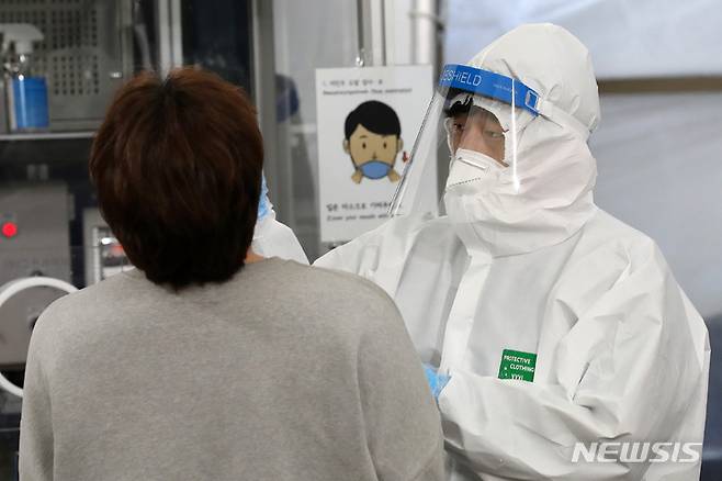 [서울=뉴시스] 지난 20일 오후 서울 송파구보건소 선별진료소에서 의료진이 검체를 채취하고 있다. 2022.01.20. livertrent@newsis.com