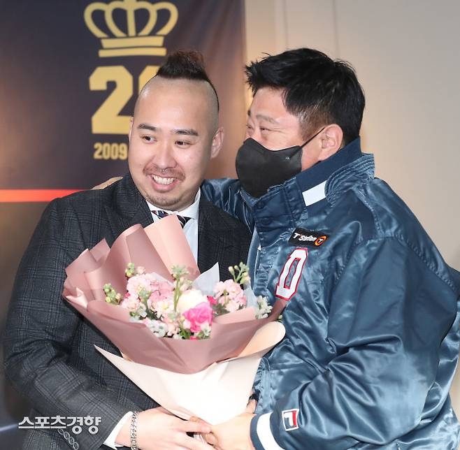 두산 유희관(왼쪽)이 지난 20일 잠실구장에서 열린 은퇴 기자회견에서 김태형 감독으로부터 꽃다발을 전달받고 있다. 정지윤 선임기자