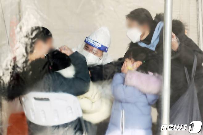 26일 오후 서울 마포구 월드컵공원 평화광장에 마련된 신종 코로나바이러스 감염증(코로나19) 임시선별진료소에서 어린이가 검사를 받고 있다. 2022.1.26/뉴스1 © News1 황기선 기자