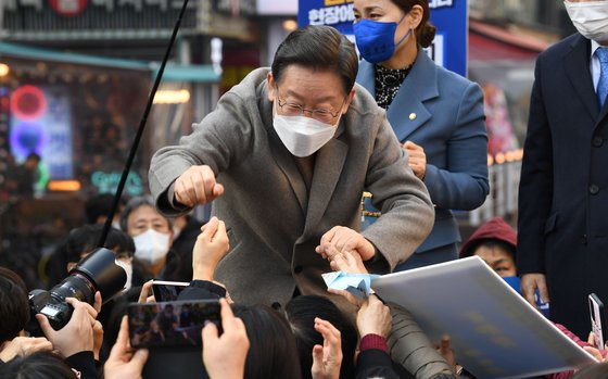 더불어민주당 이재명 대선 후보가 26일 경기 광명시 철산로데오거리에서 연설을 마친 뒤 지지자들과 주먹 악수를 나누고 있다. 김상선 기자