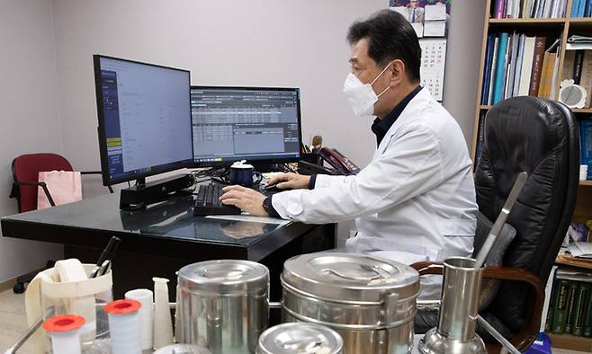 신종 코로나바이러스 감염증(코로나19) 신규 확진자가 8571명 발생한 25일 서울 구로구의 한 의원에서 의사가 재택치료 업무를 하고 있다. 뉴스1