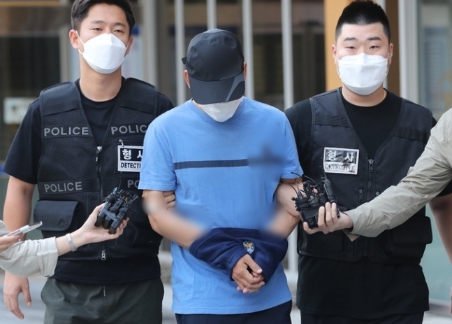 장인 앞에서 아내를 일본도(장검)로 찔러 살해한 혐의를 받고 있는 장모(가운데)씨가 지난해 9월10일 서울 강서경찰서에서 검찰로 송치되고 있다. 뉴스1 