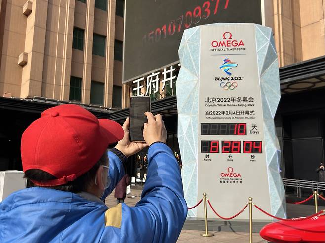 2022년 1월 25일 오후 중국 베이징 중심가 왕푸징에 세워진 베이징 동계올림픽 카운트다운 시계탑 앞에서 시민들이 기념 촬영을 하고 있다. /연합뉴스