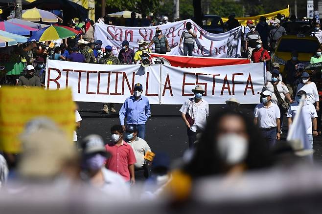 2021년 12월 12일(현지시간) 엘살바도르에서 시민들이 '비트코인 사기'라는 현수막을 들고 비트코인 법정화폐 도입 반대 시위에 나서고 있다. /사진=AFP