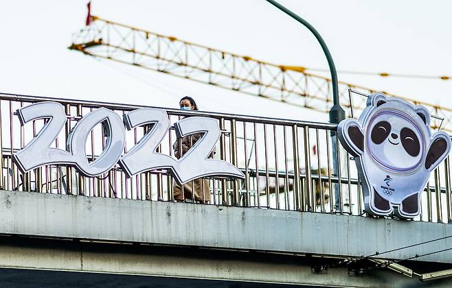 현지시간 27일 한 여성이 베이징올림픽 마스코트 빙둔둔을 지나쳐 가고 있다. / 사진 = 연합뉴스