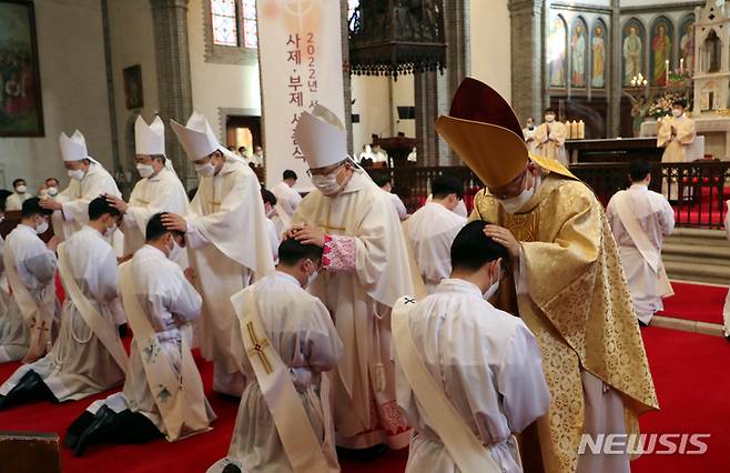 [서울=뉴시스] 사진공동취재단 = 28일 서울 중구 명동성당에서 열린 천주교 서울대교구 사제 서품식에서 사제 수품 후보자들이 정승택 대주교와 주교단에게 안수를 받고 있다. 2022.01.28. photo@newsis.com
