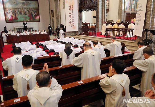 [서울=뉴시스] 사진공동취재단 = 28일 서울 중구 명동성당에서 열린 천주교 서울대교구 사제 서품식에서 사제 수품 후보자들이 세상에 죽고 하느님께 봉사하겠다는 것을 드러내기 위해 부복하고 있다. 2022.01.28. photo@newsis.com