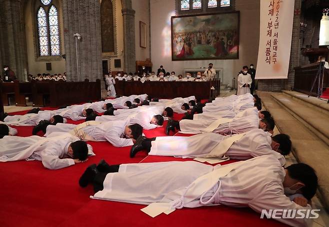 [서울=뉴시스] 사진공동취재단 = 28일 서울 중구 명동성당에서 열린 천주교 서울대교구 사제 서품식에서 사제 수품 후보자들이 세상에 죽고 하느님께 봉사하겠다는 것을 드러내기 위해 부복하고 있다. 2022.01.28. photo@newsis.com